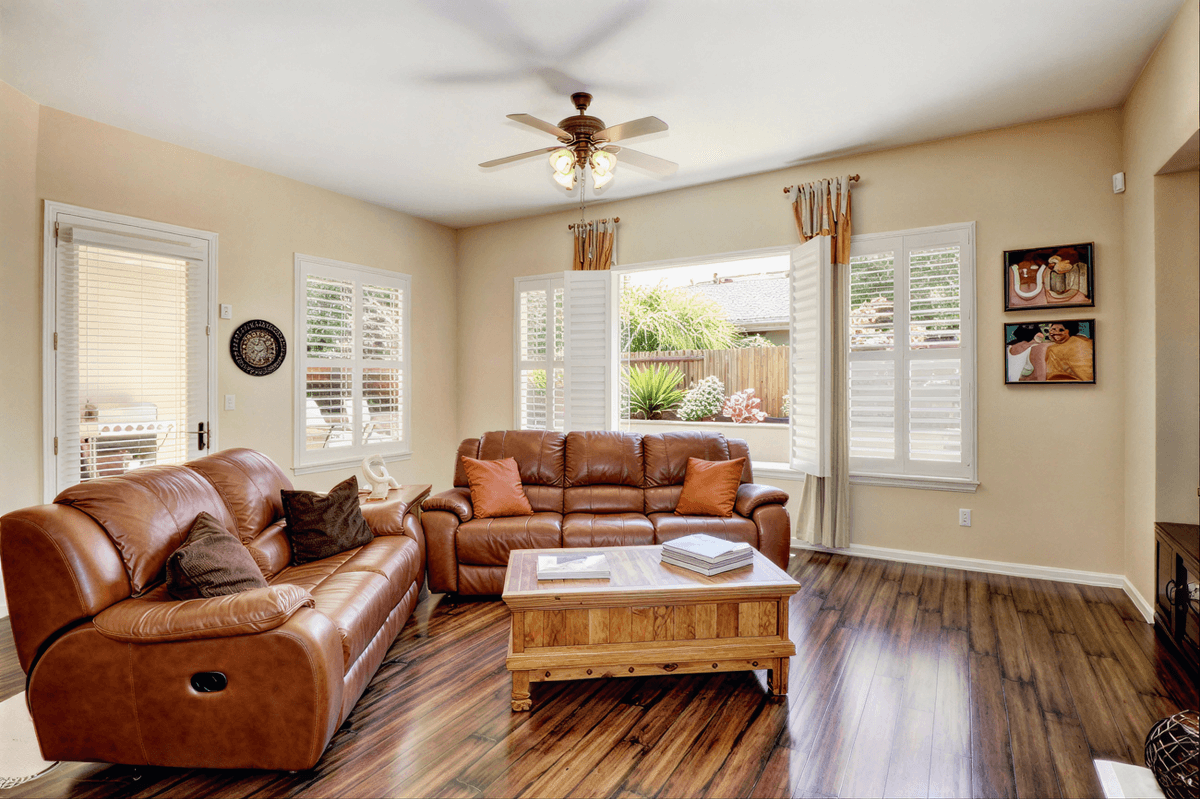 Living room with leather couches and ceiling fan